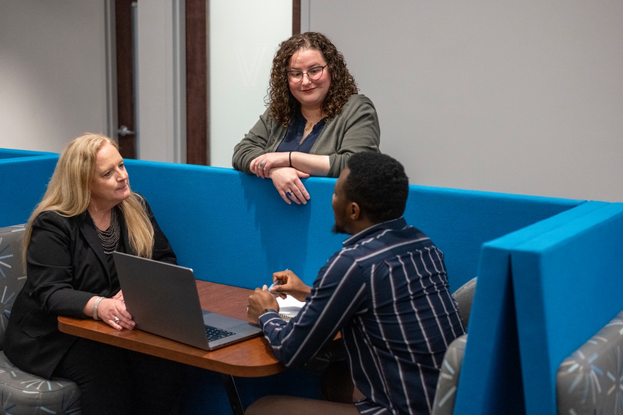 Two career center staff members speakign with a student.