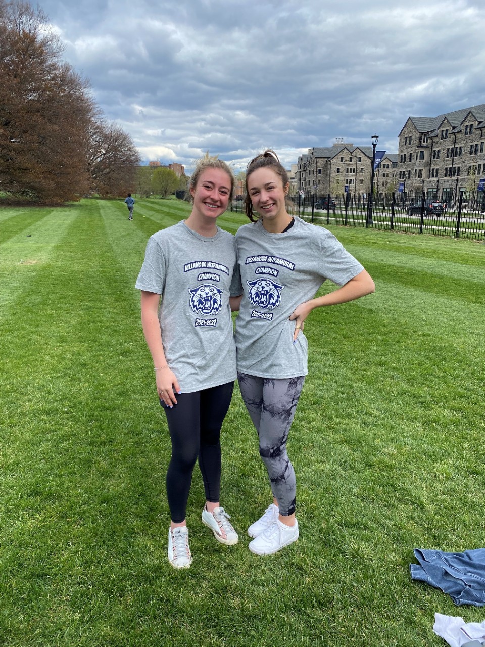 Two female students posing for doubles tennis champion photo