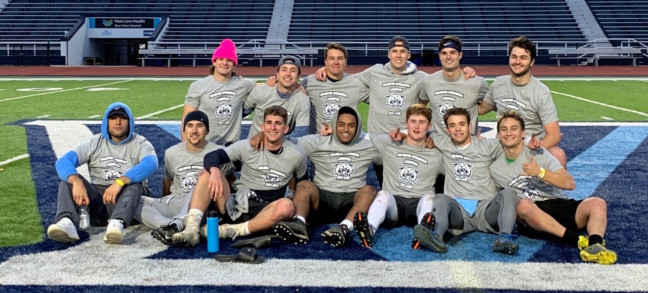 Male students posing for flag football champion photo