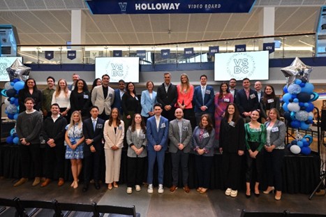 students and professionals posing in front of stage